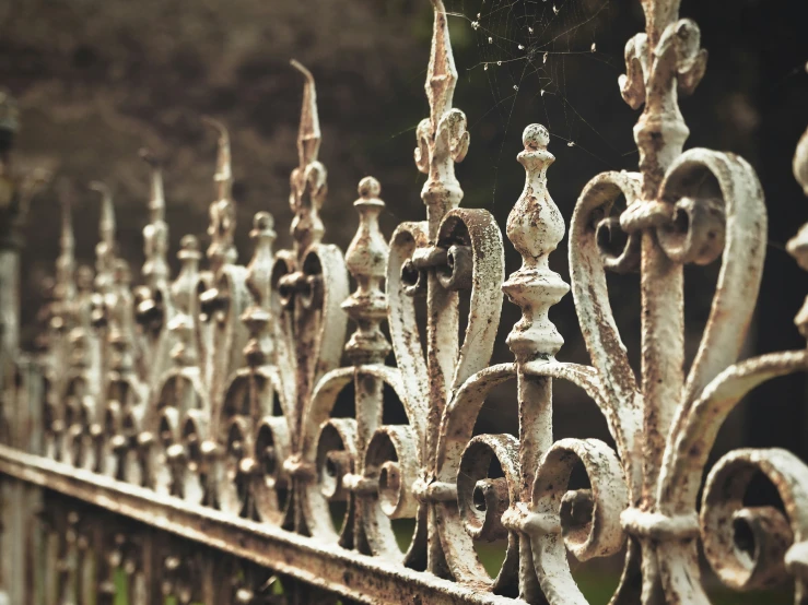 an iron fence with different ornaments and chains