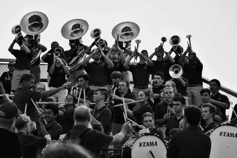 some young men with marching instruments and onlookers