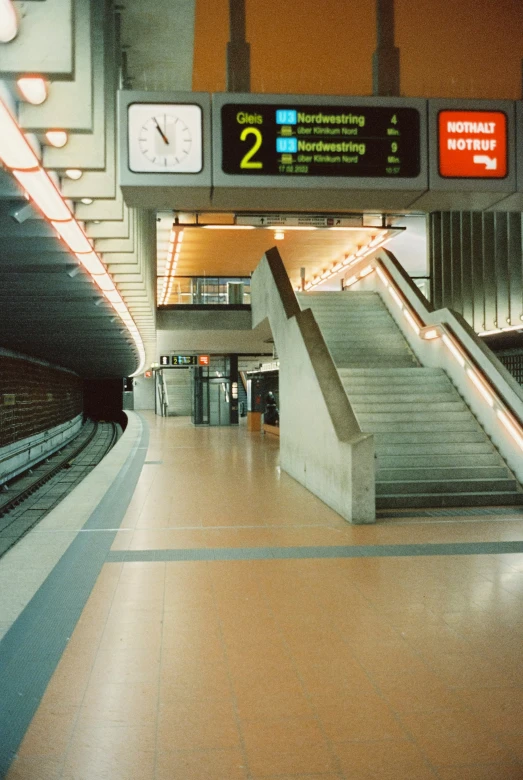 an empty station with a bunch of steps leading up to the platform