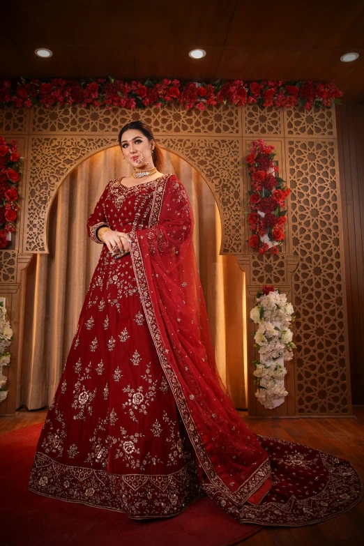 a woman wearing an indian style red bridal suit
