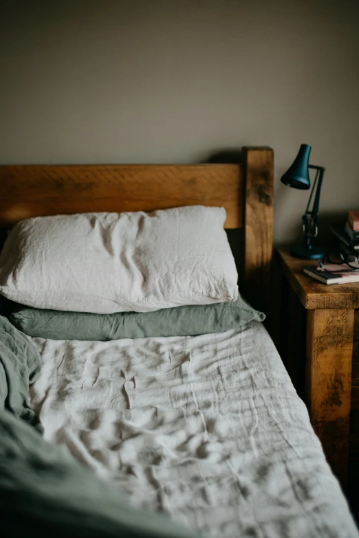 a wooden headboard near a bed with light in room