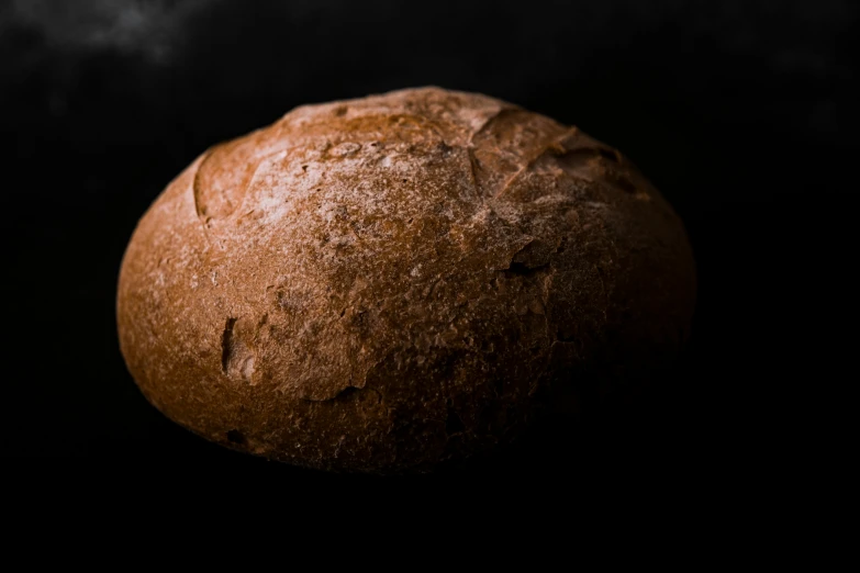 a loaf of fresh baked bread on a black background