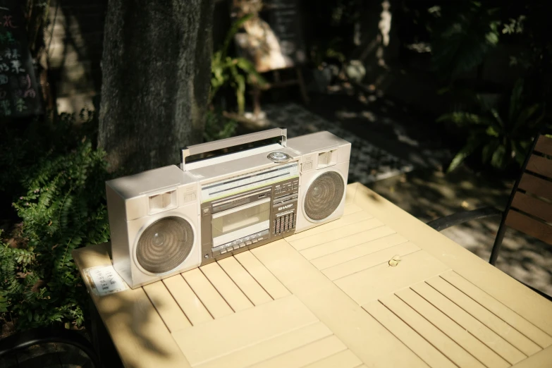 an old radio next to a tree in the sun