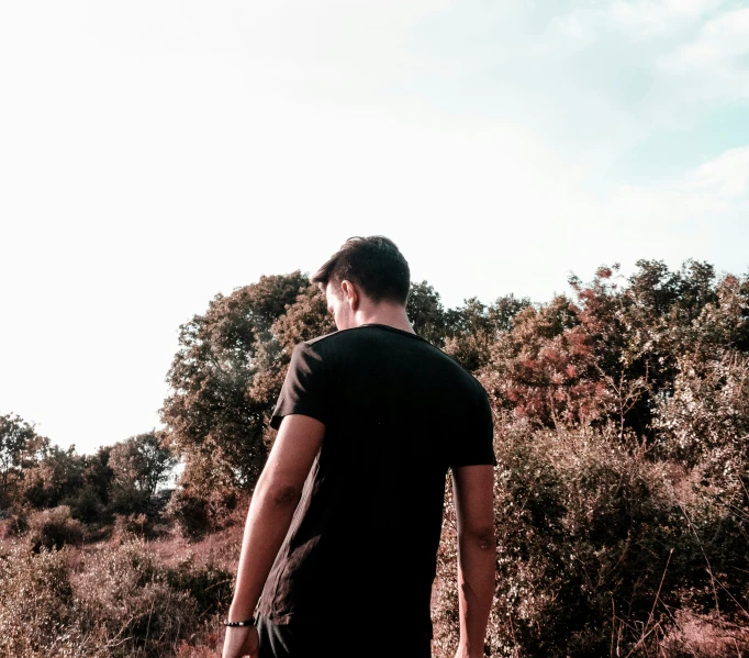 a man looking over the top of some brush