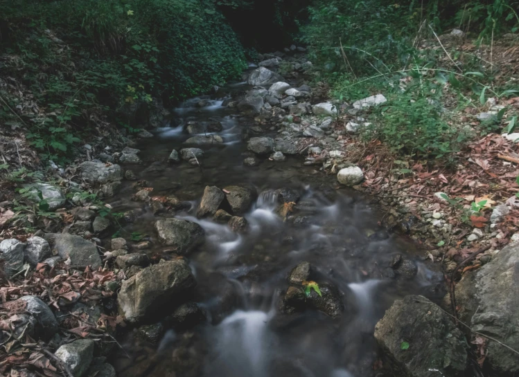 a creek runs between rocks and a small patch of ground