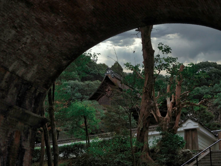 an old building sitting on a cliff above a tree filled forest