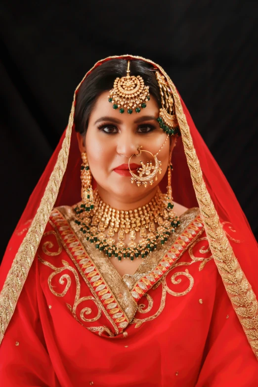 a woman with a head piece and nose ring in an ethnic wedding outfit