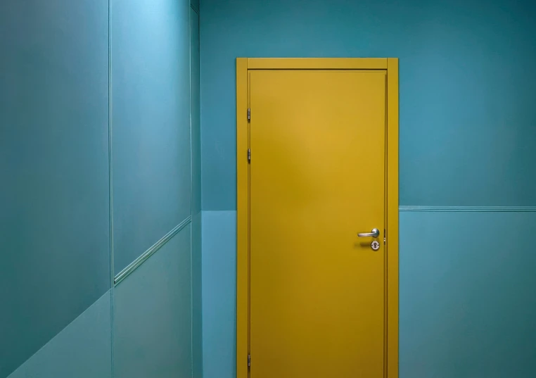 the door to the restroom is open and has yellow painted doors