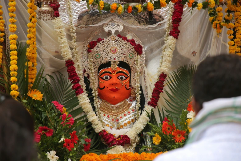 a statue that is decorated with flowers and garland