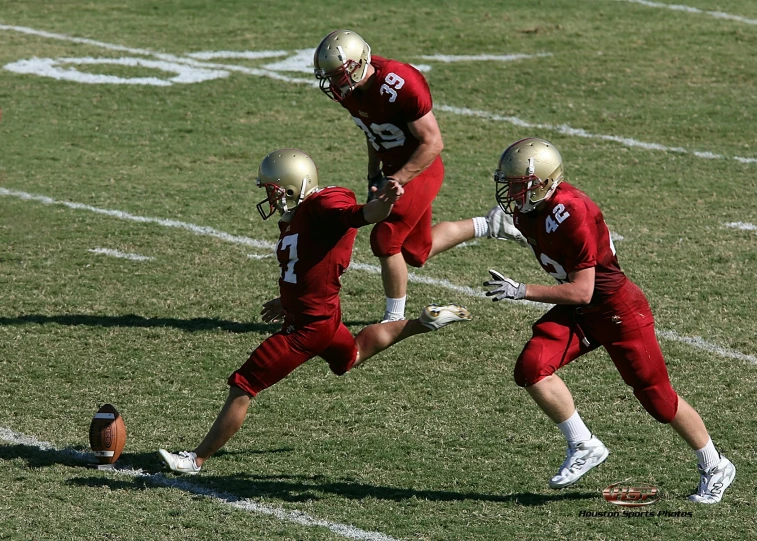 three men playing football against each other on the field