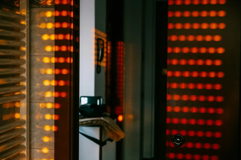 a mirror has a clock next to it and is reflecting a wall of lights