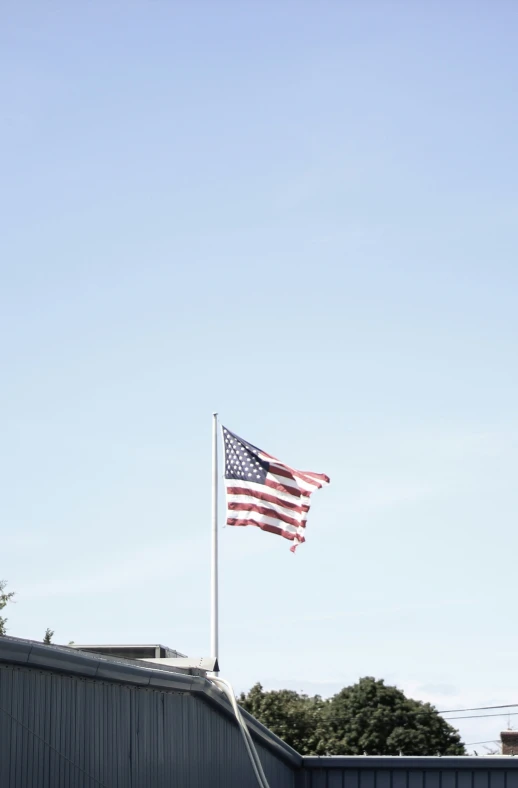 an american flag flying in the air above a building