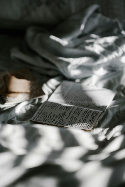 an open book sitting on top of a bed