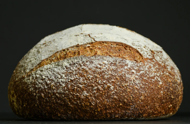 a bread loaves into large balls and on a black surface