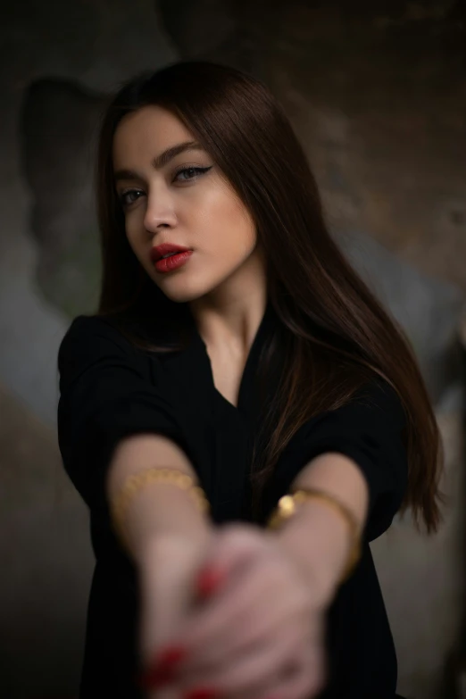 a woman with red lipstick and a gold celet is making the hand sign