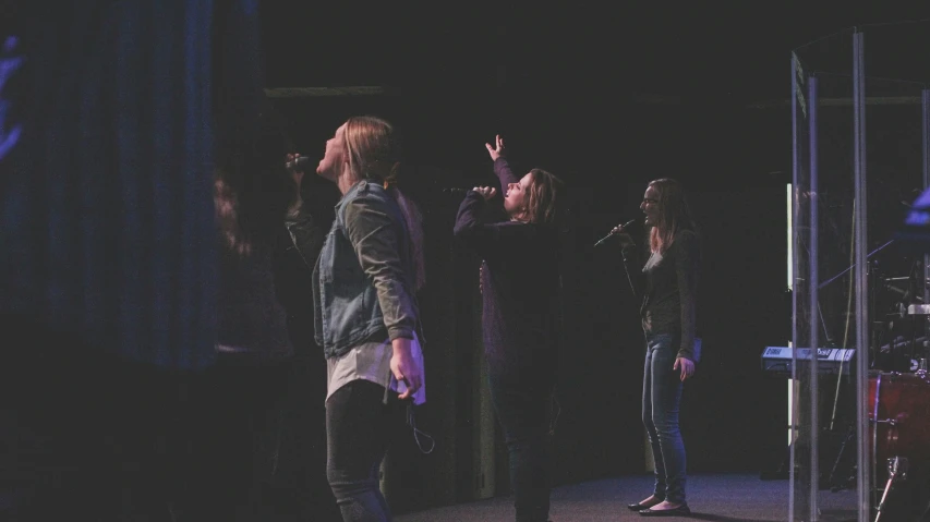 several people stand on a stage in front of a microphone