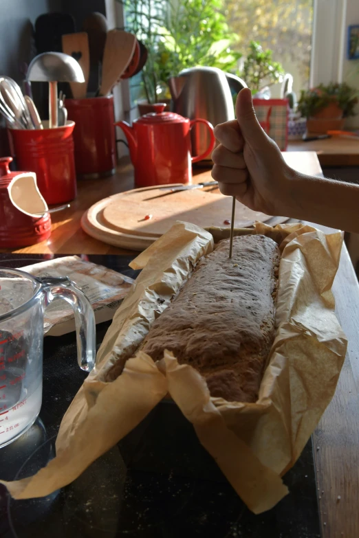 a man  into a large piece of food on a counter