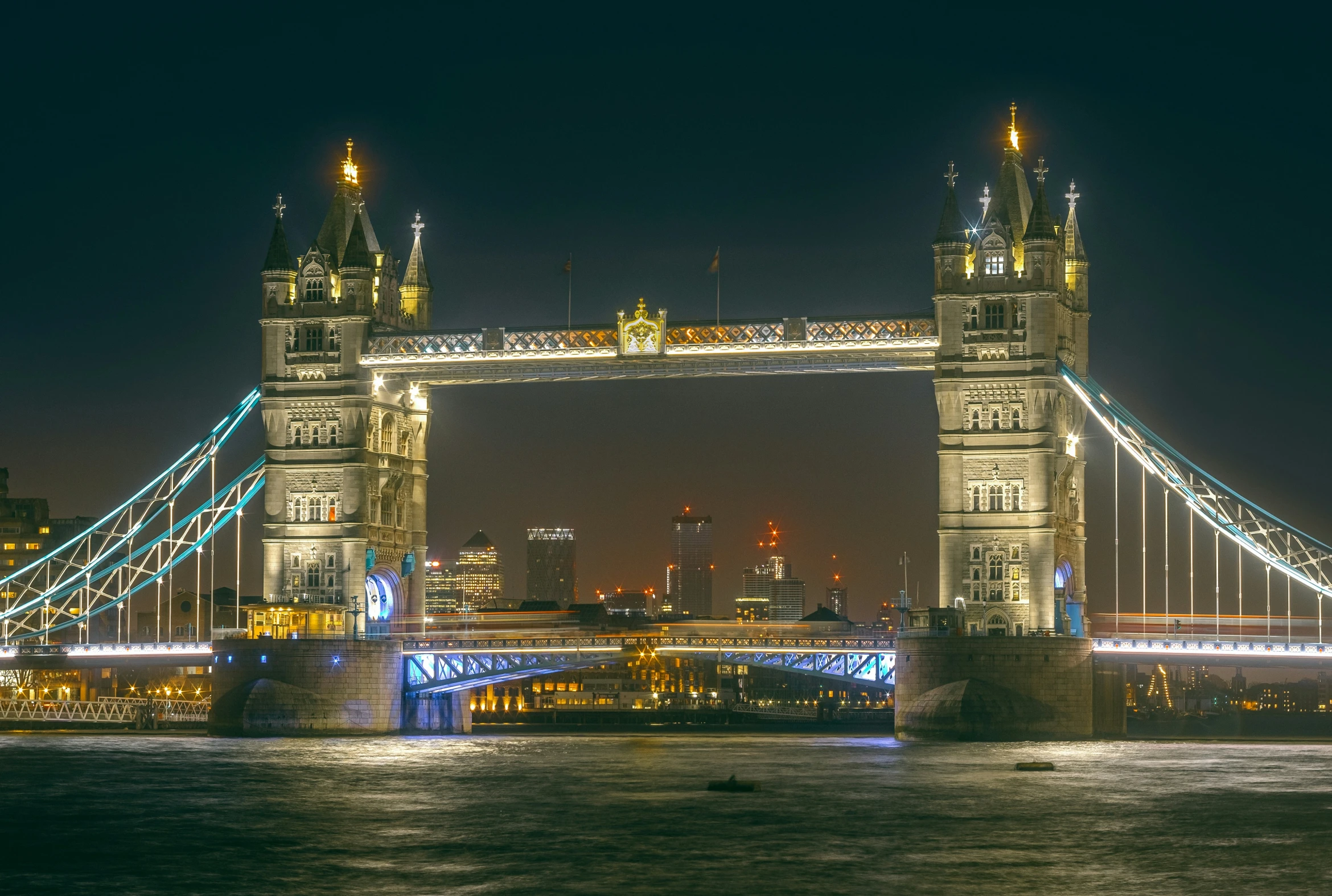 the tower bridge at night with many lights on