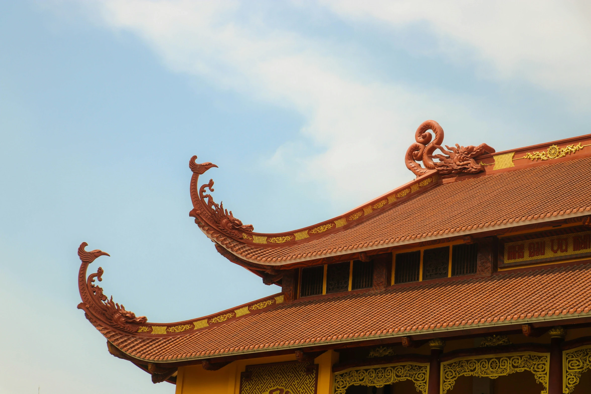 an oriental roof with gold decorations on top