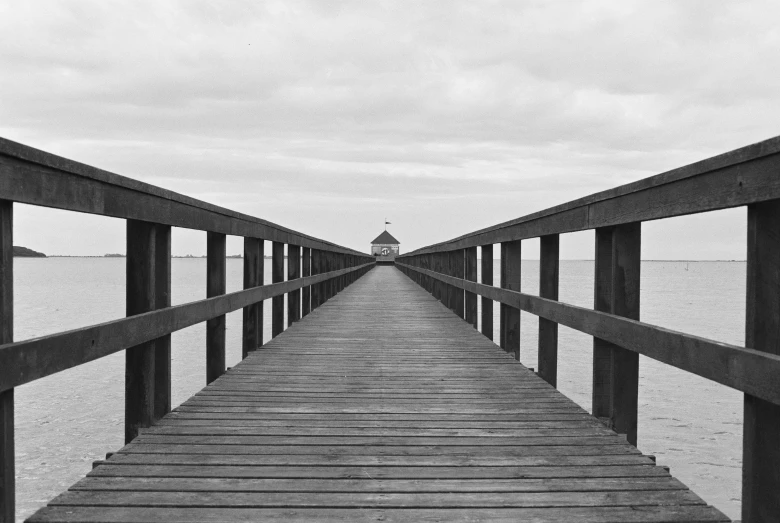 a small wooden pier on the water with a sky background