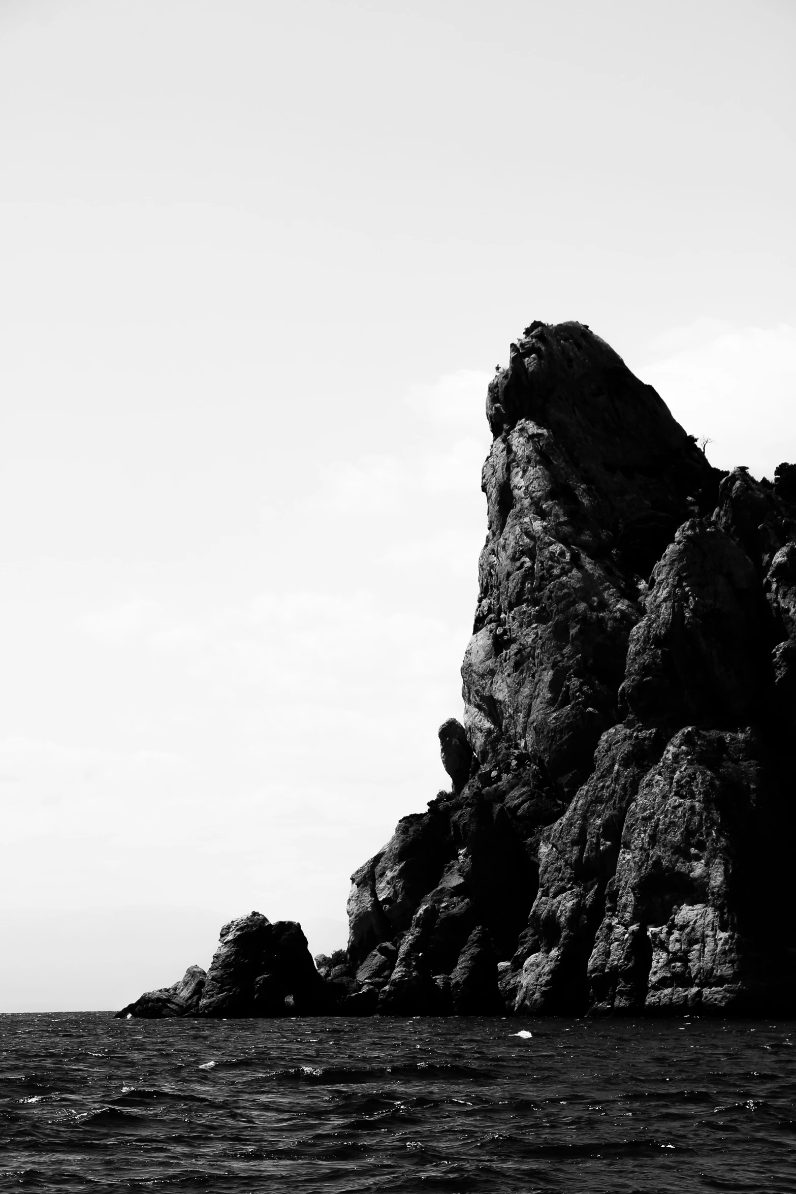 an black and white po shows the rock formation next to the ocean