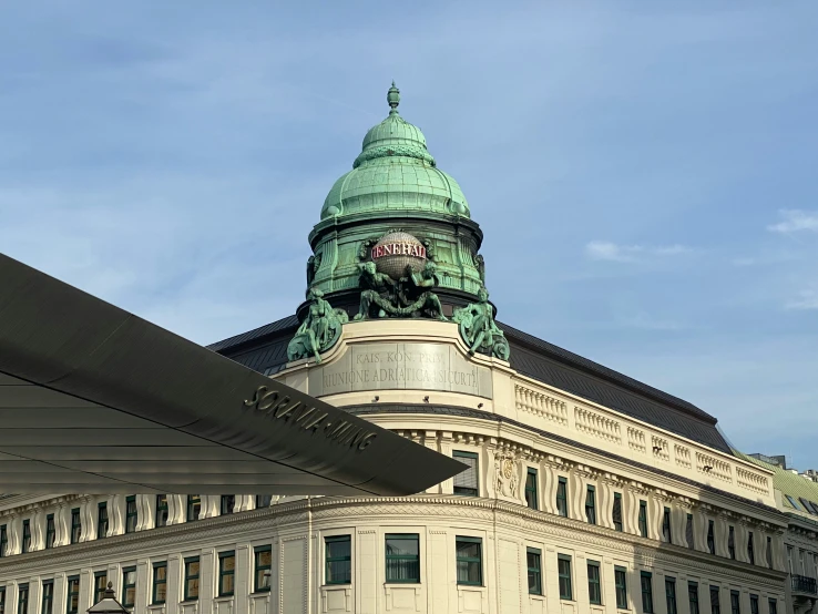 a tall building with a large green dome and clock