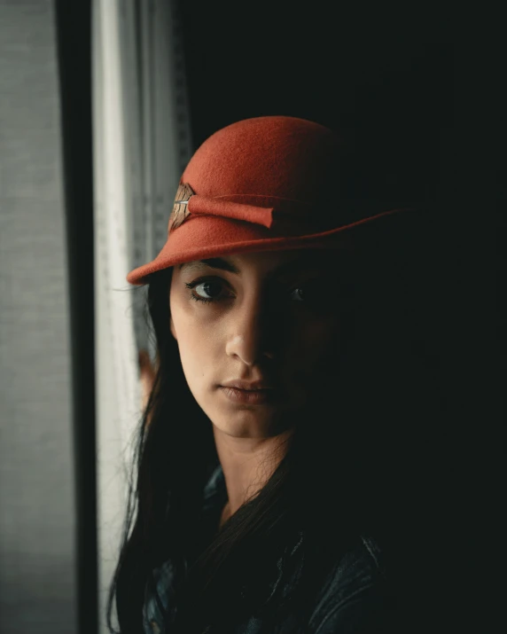 a woman with dark hair wearing a red hat