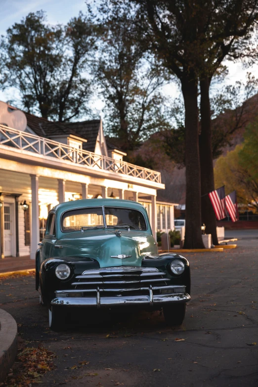 an old - fashioned car sits in front of a white house