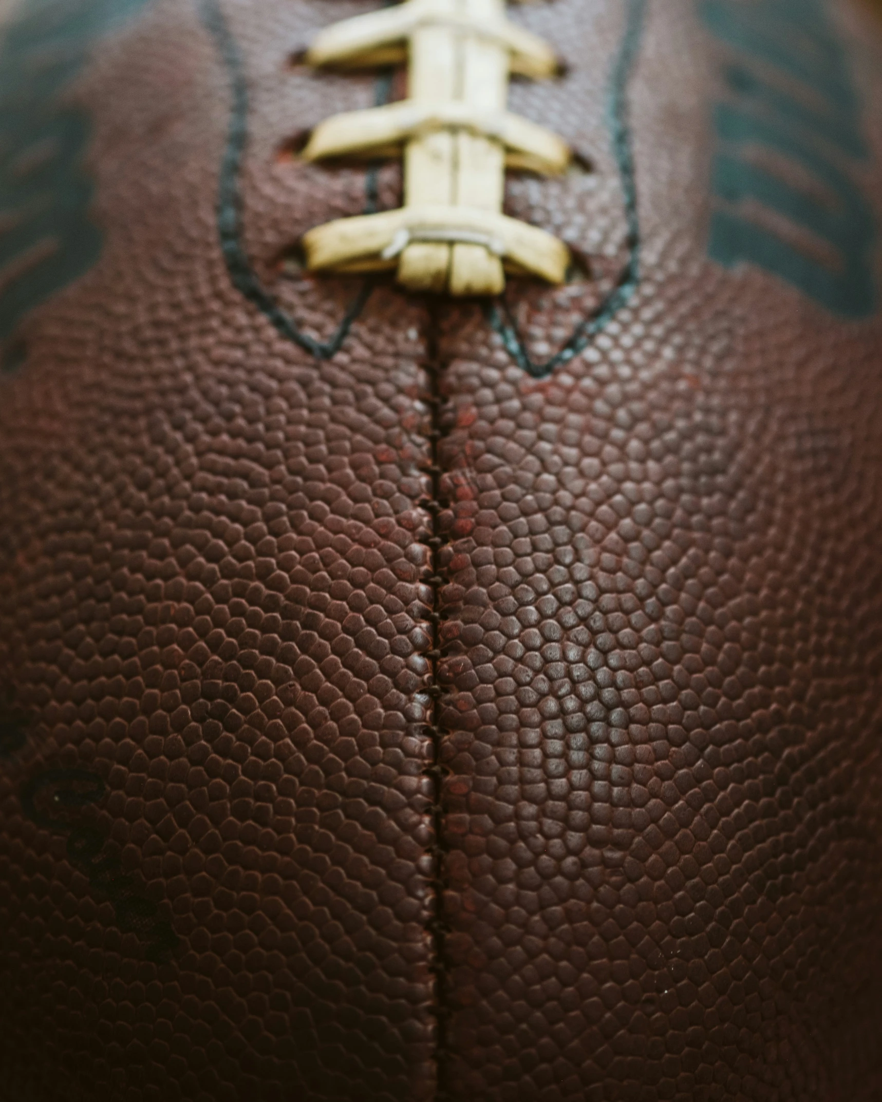 a close up of a leather ball with stitchs and a gold metal ring on it