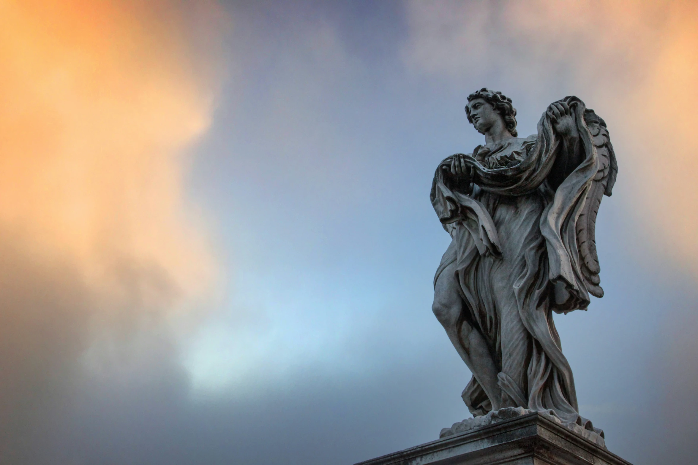 a stone statue with an angel on the top of it