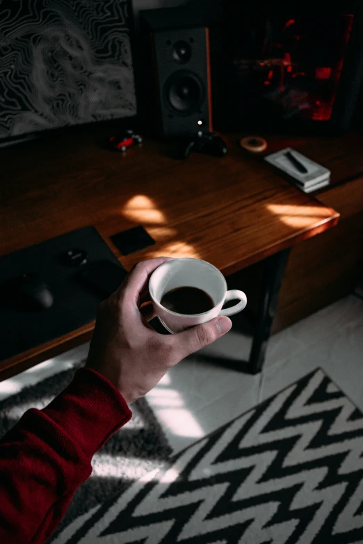 the person is holding their cup of coffee