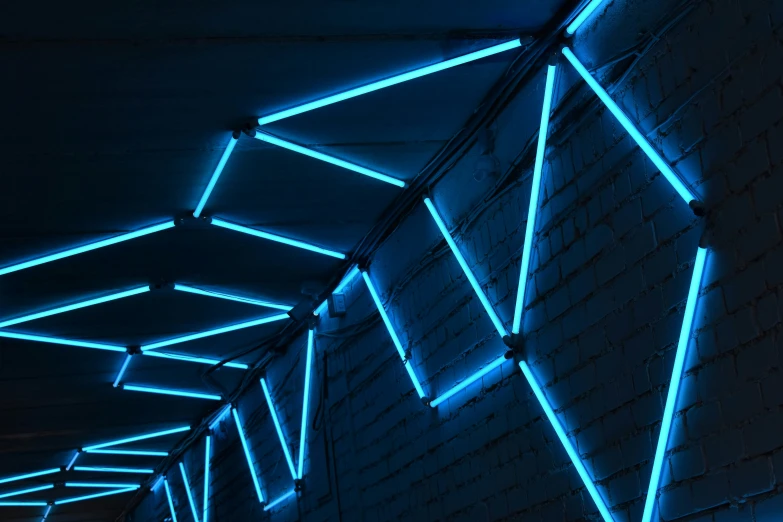 a walkway covered in blue lights and hanging off of ceiling