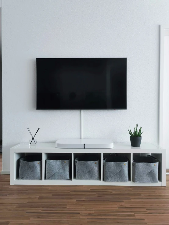 a tv is on top of a white entertainment unit