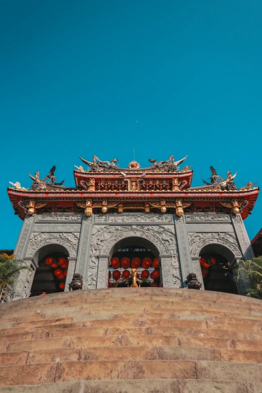 a clock tower with statues on top against a blue sky