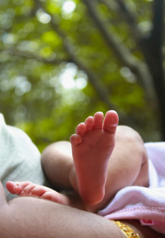 a baby laying on its side being held by a parent