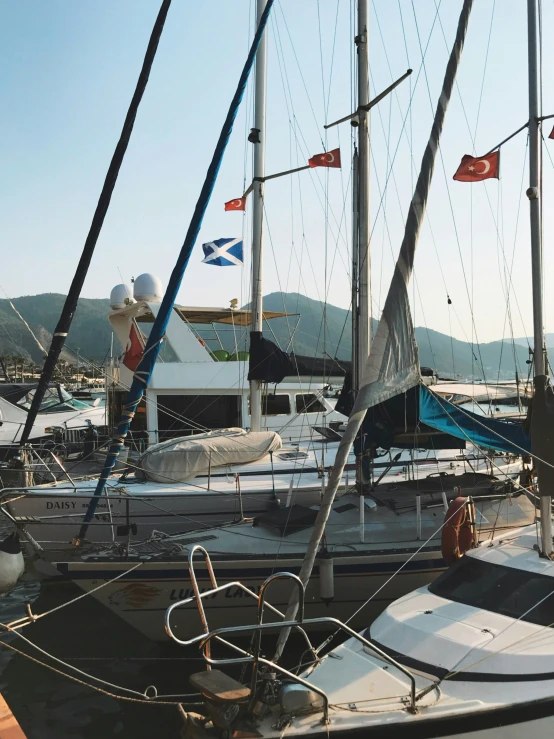 several sail boats with flags next to each other