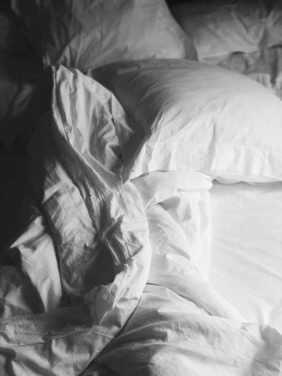 a white bed covered with a pile of pillows