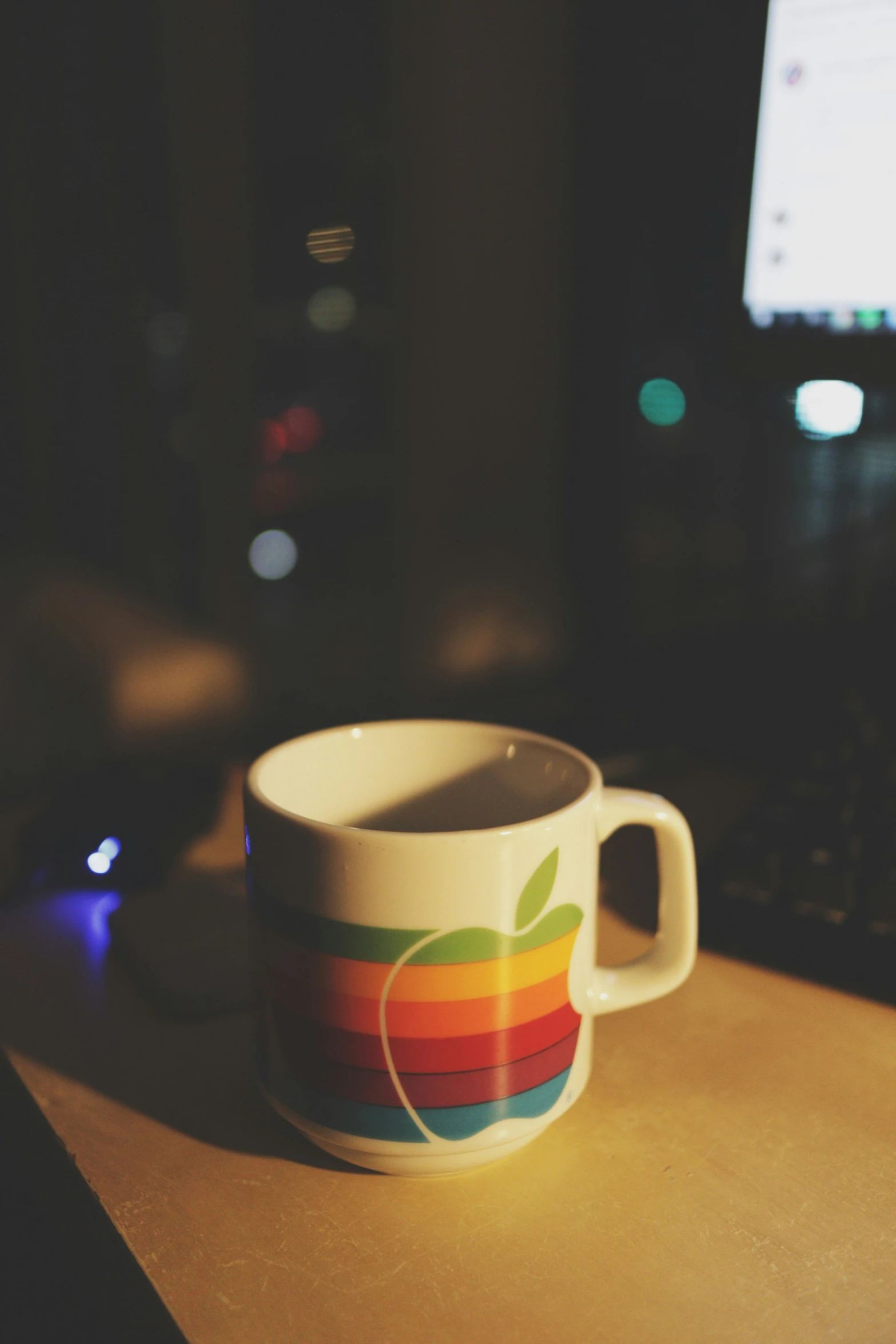 an apple mug sitting on top of a desk