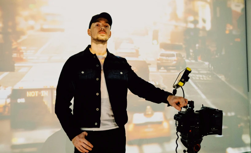 a man standing next to a camera on top of a wall