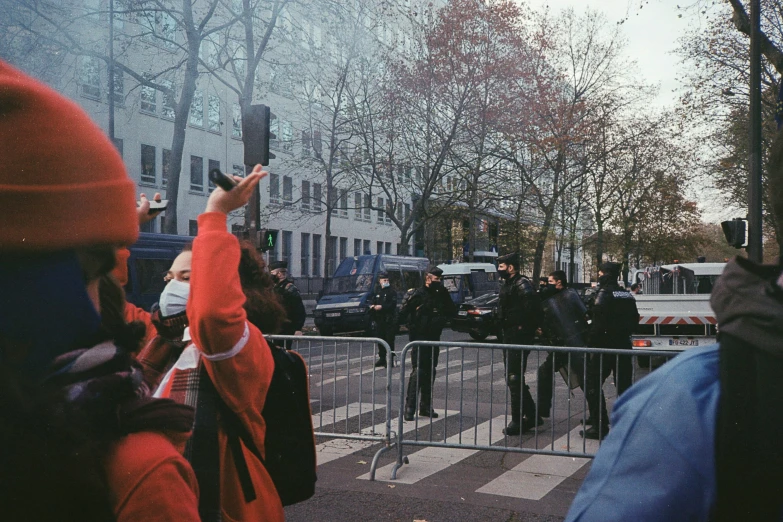 people are standing in front of a metal fence