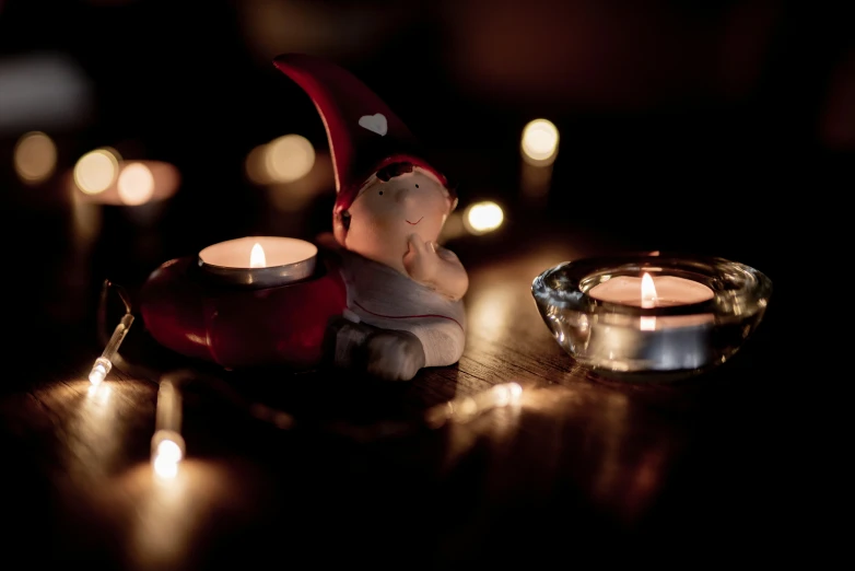 a small candle lit next to a silver bowl