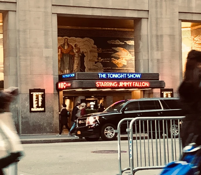 a man walking down the street in front of a theatre