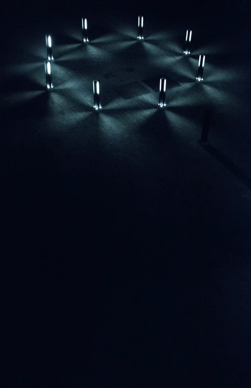 a black room with many light bulbs on the ceiling