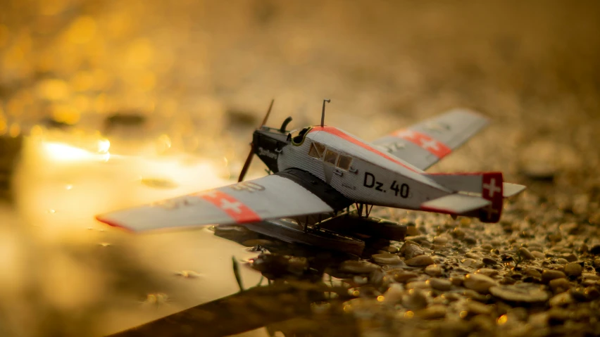 a miniature airplane is sitting on some gravel