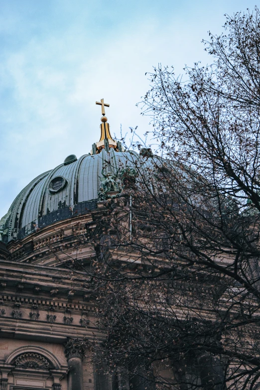 a view from behind looking up at a statue and domed building