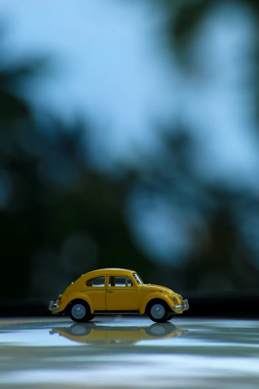 a small yellow toy car sitting on top of a counter