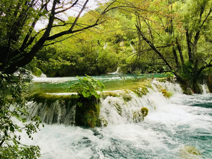 the man in the water is standing by the waterfall