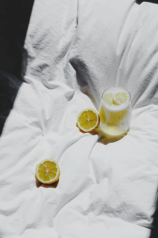 a glass of lemon juice on a white blanket