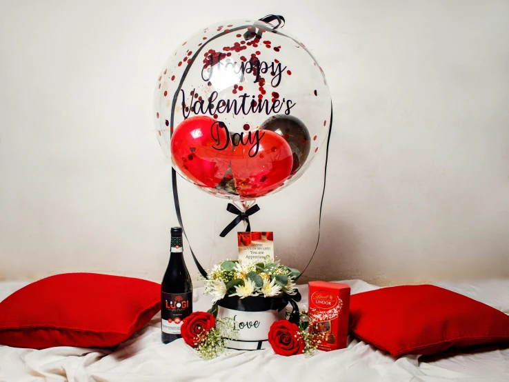 two balloons and a bottle with the words happy valentine's day