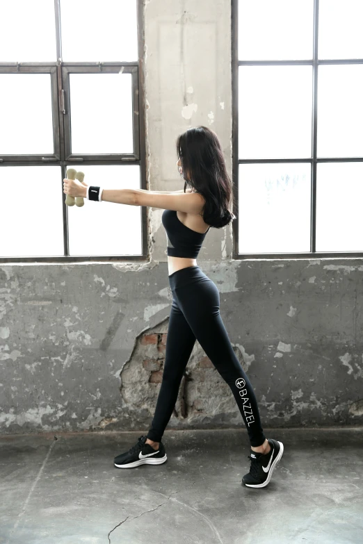 a woman holding onto a bottle and making her way through an industrial building